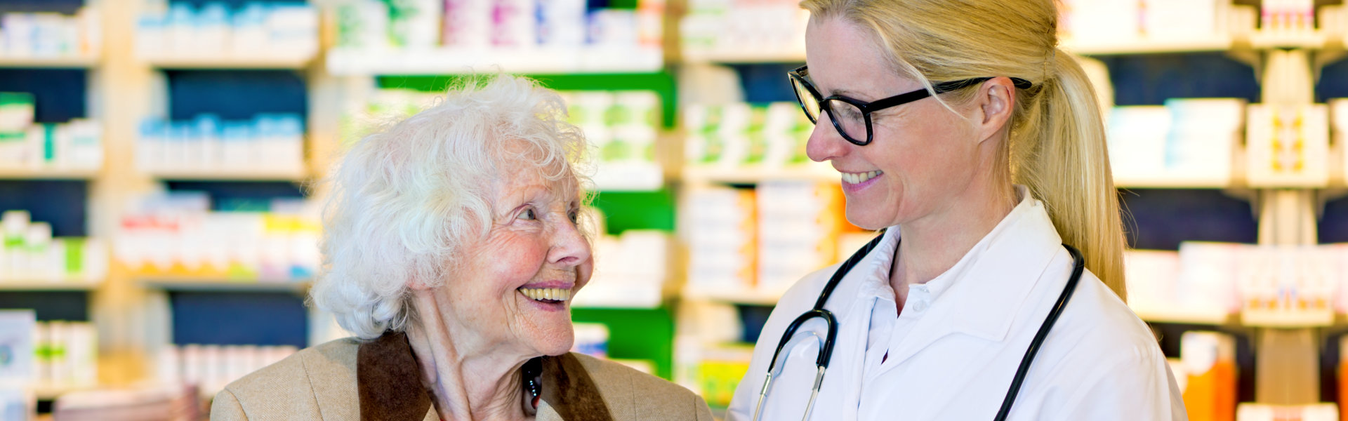 pharmacist and eldelry woman smiling at each other