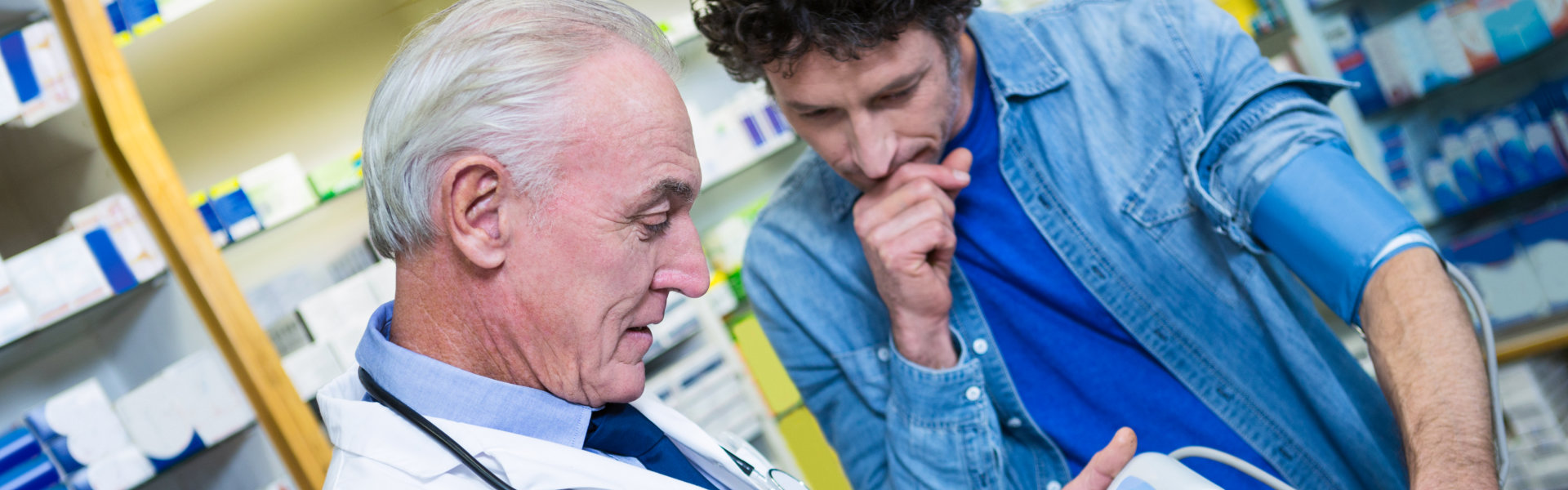 pharmacist checking blood pressure of customer