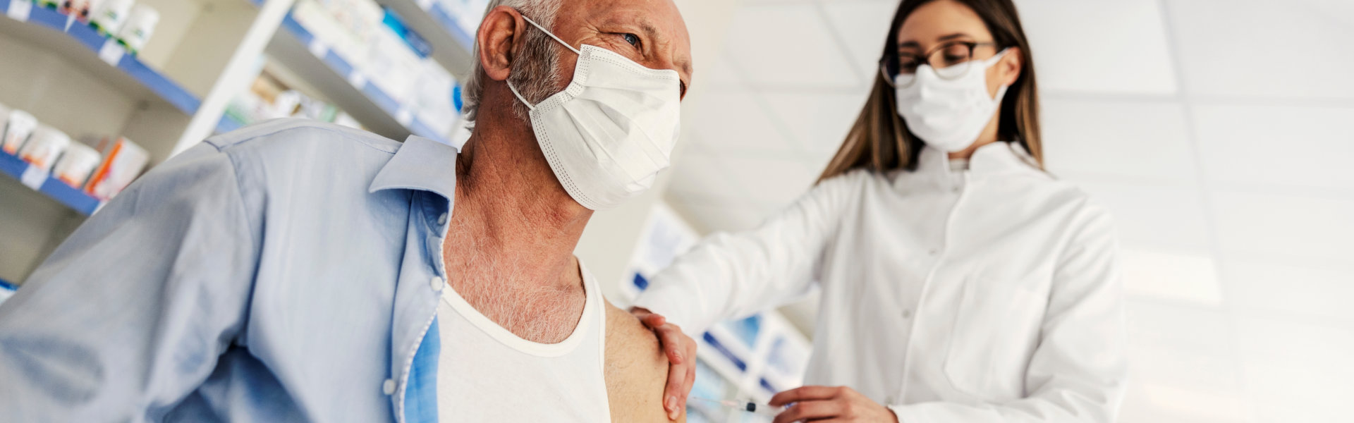 elderly man getting vaccine at pharmacy