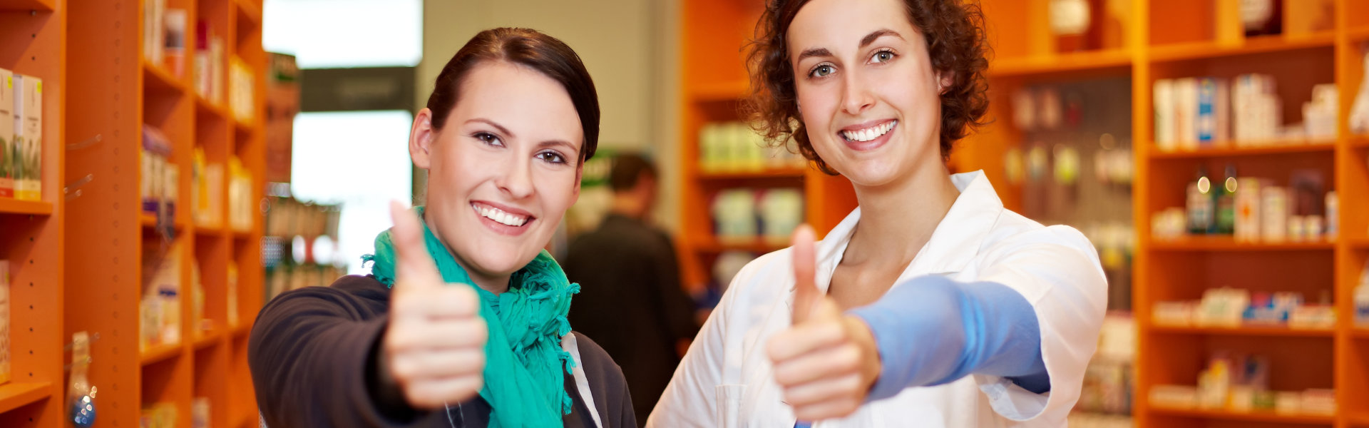 two women showing thumbs up